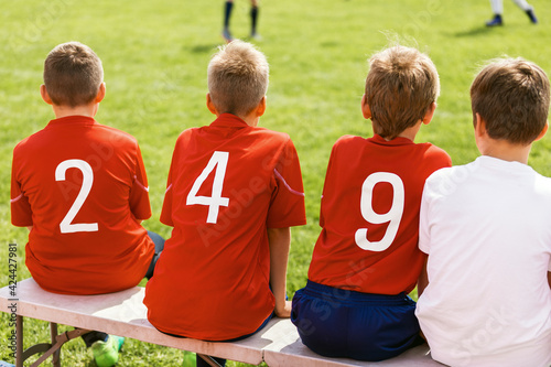 Soccer Team Player Sitting Together on Substitutes' Bench. Kids Playing Sports Game in Summer Time.