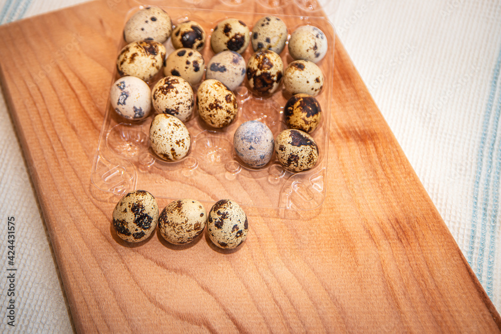 fresh quail eggs in a plastic box on a wooden board, quail eggs for a delicious Easter holiday in a tray, preparation for Easter, healthy dietary food, diet fresh quail eggs in a plastic box on a wooden board, quail eggs for a delicious Easter holiday in a tray, preparation for Easter, healthy dietary food, diet