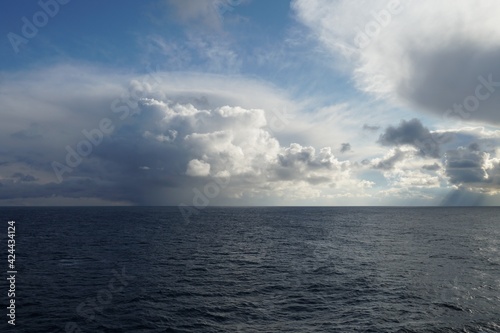 Largely overcast sky with heavy rainfall clouds bringing abundant rainfall and atmospheric precipitation observed on Pacific ocean near North America coast.