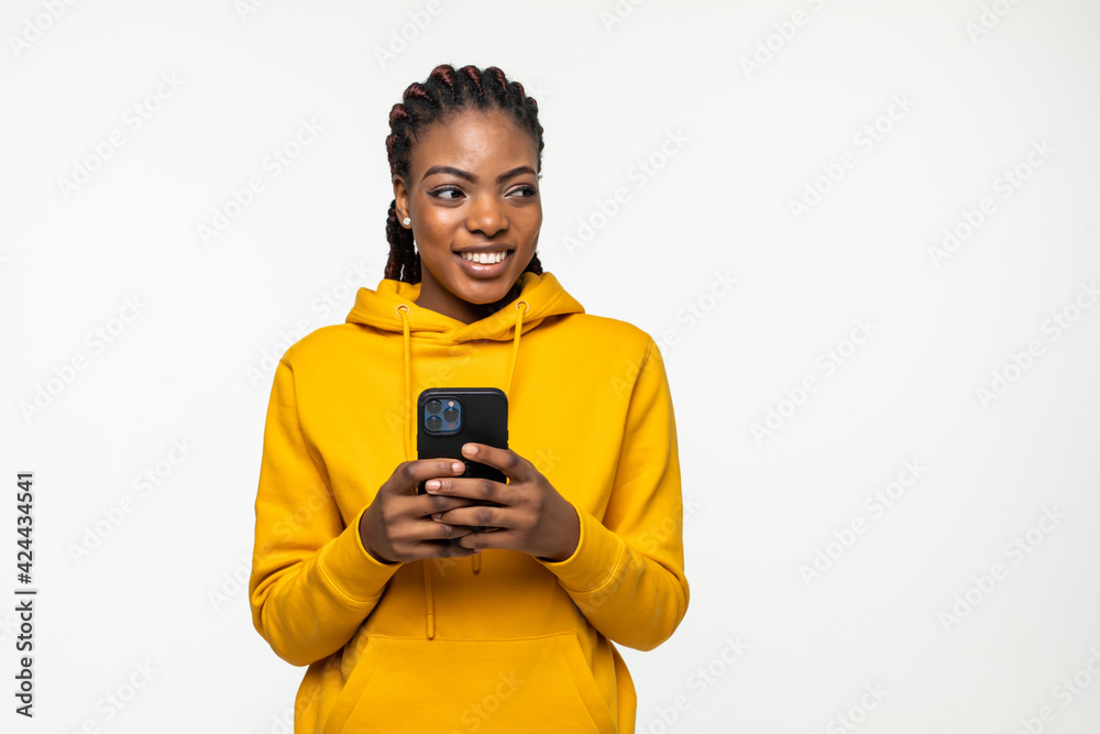 Fototapeta premium Happy african woman texting on her phone isolated over white background