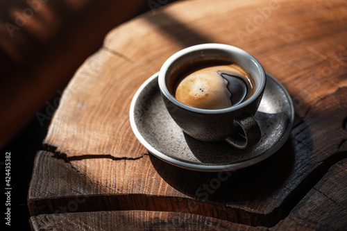 Bild auf Leinwand Coffee cup of black coffee on solid oak stump coffee table