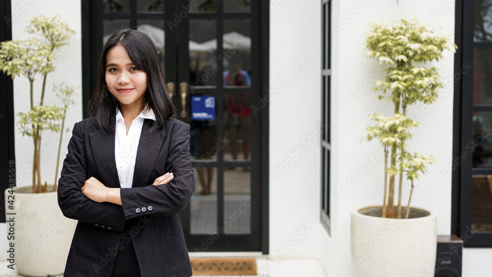 Asian business woman smiling and standing in front office Asian business woman smiling and standing in front office