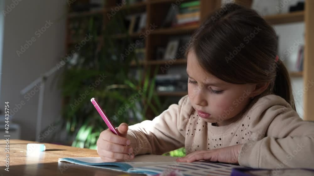 Little girl doing homework calculating with her fingers Little girl doing homework calculating with her fingers