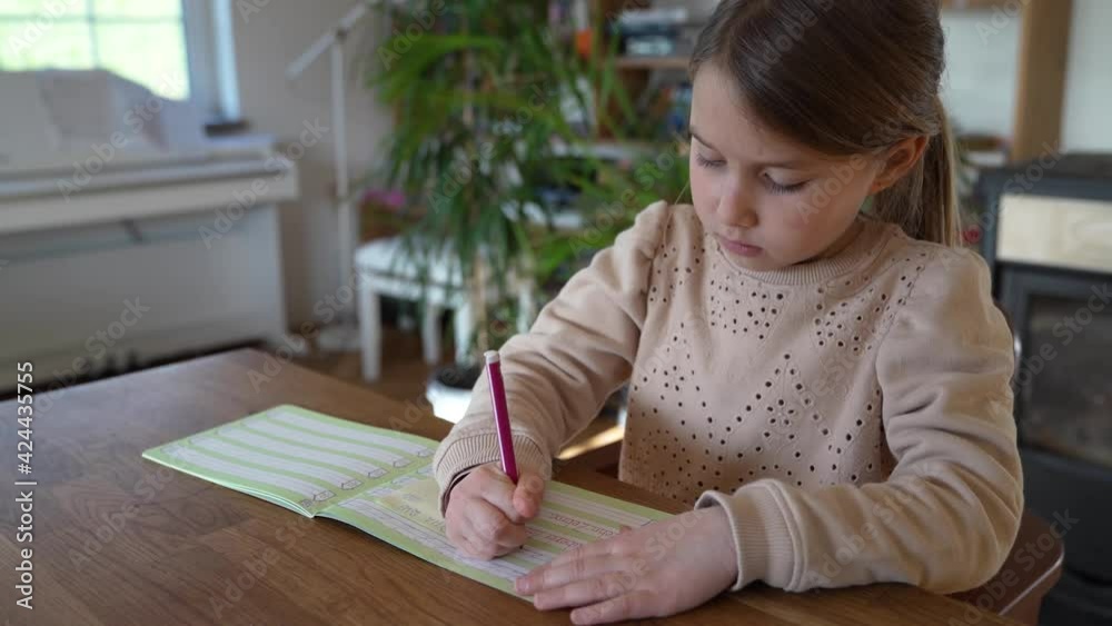 Little girl writing in excercise book, doing homework Little girl writing in excercise book, doing homework