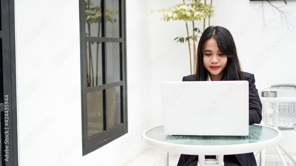 Asian young business woman working on computer in office Asian young business woman working on computer in office