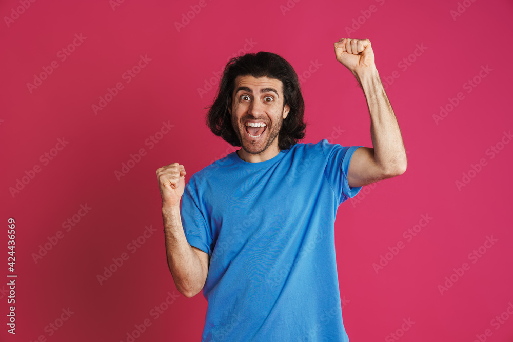 Excited brunette man screaming and making winner gesture Excited brunette man screaming and making winner gesture