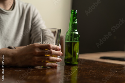 Фотография Guy holding a glass of beer sitting in a pub