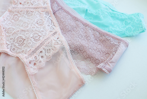 women's, lace panties, pink, turquoise, laid out on a light background. Difficulties in choosing underwear, fashion, health, beauty. Women's multicolored lace panties © Olga