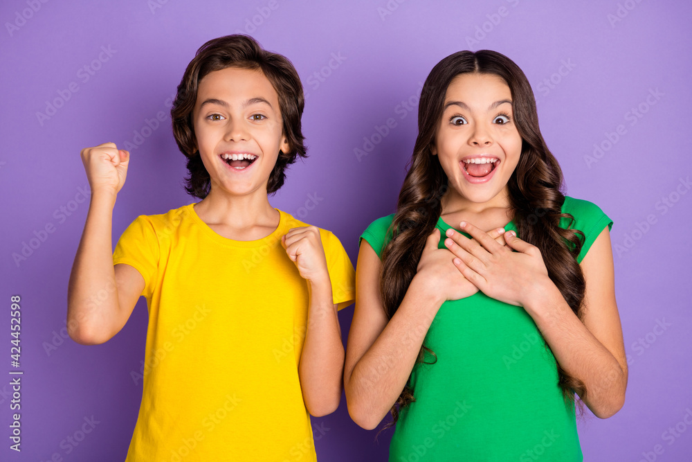 Photo of two kids happy positive smile amazed excited celebrate win victory boy fists hands isolated over violet color background Photo of two kids happy positive smile amazed excited celebrate win victory boy fists hands isolated over violet color background