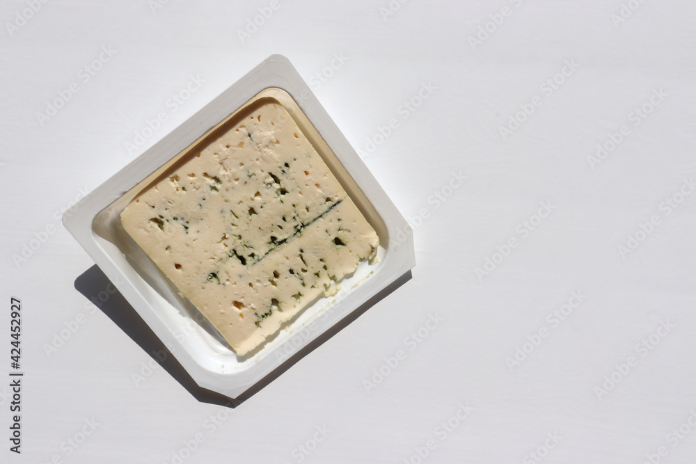 Blue gorgonzola cheese in package on white table background. Top view, copy space Blue gorgonzola cheese in package on white table background. Top view, copy space