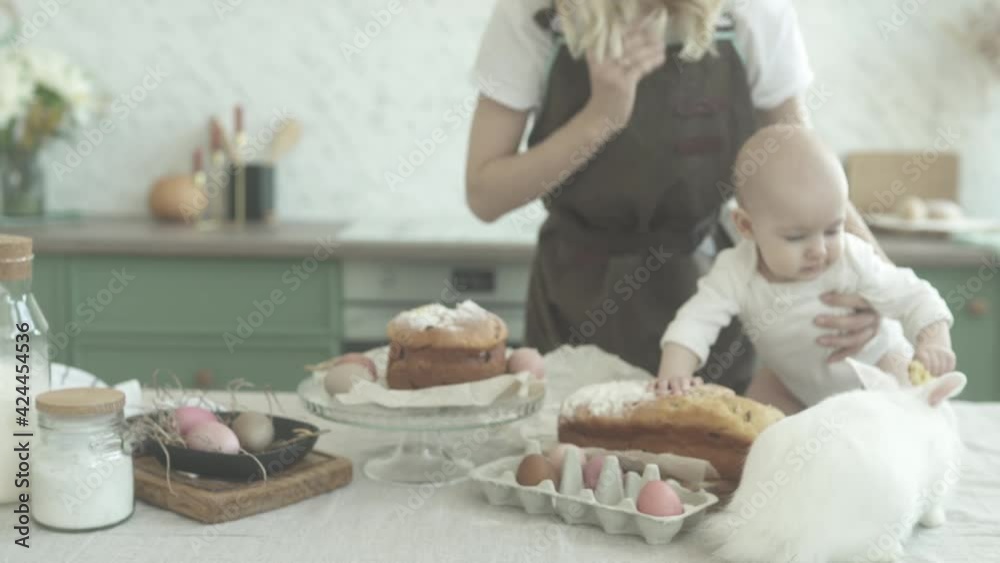 A young mother and her daughter are preparing an Easter table for the holiday. Mom and daughter decorate the festive table. Easter table. Easter bread. A young mother and her daughter are preparing an Easter table for the holiday. Mom and daughter decorate the festive table. Easter table. Easter bread.