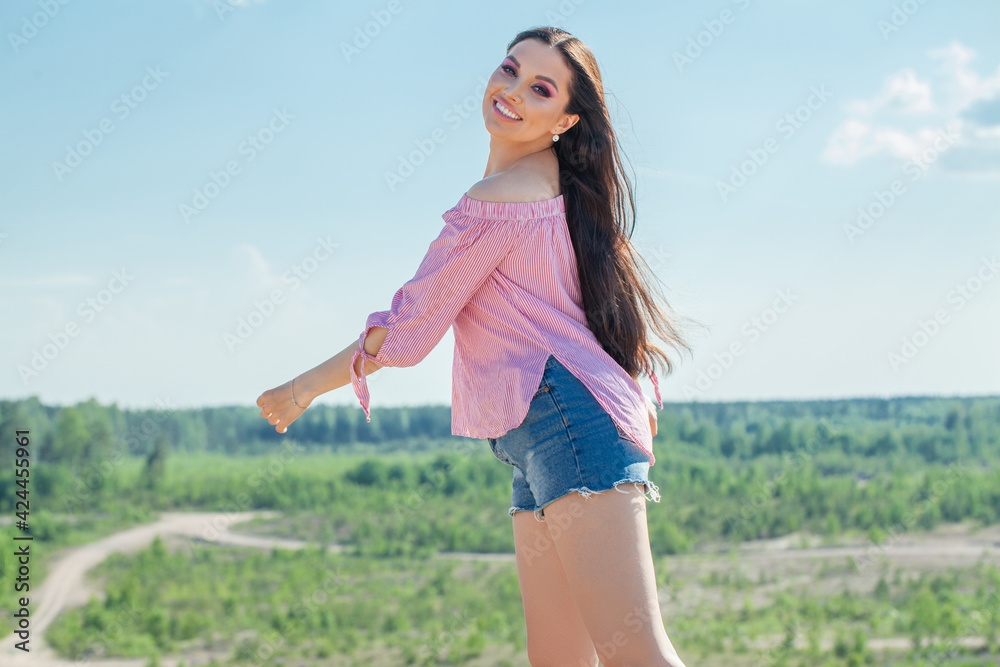 Beautiful smiling woman in summer day against blue sky outdoors