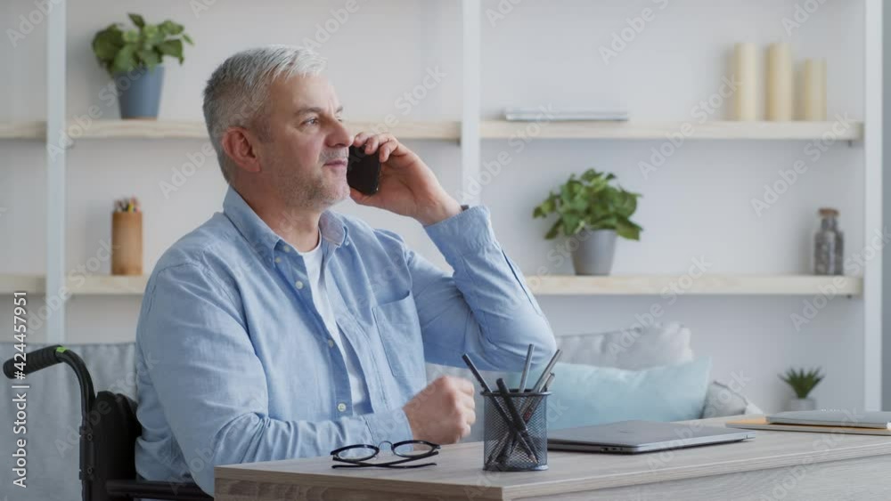 Handicapped Man Talking On Phone Sitting In Wheelchair At Home Handicapped Man Talking On Phone Sitting In Wheelchair At Home