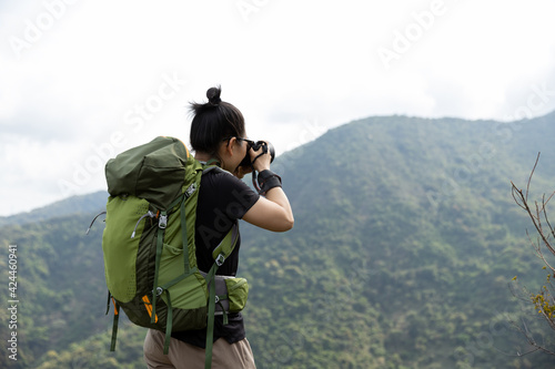 Woman photographer taking pictures in spring mountain