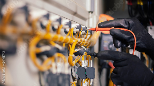 Fotografía Electrician engineer work tester measuring voltage and current of power electric line in electical cabinet control