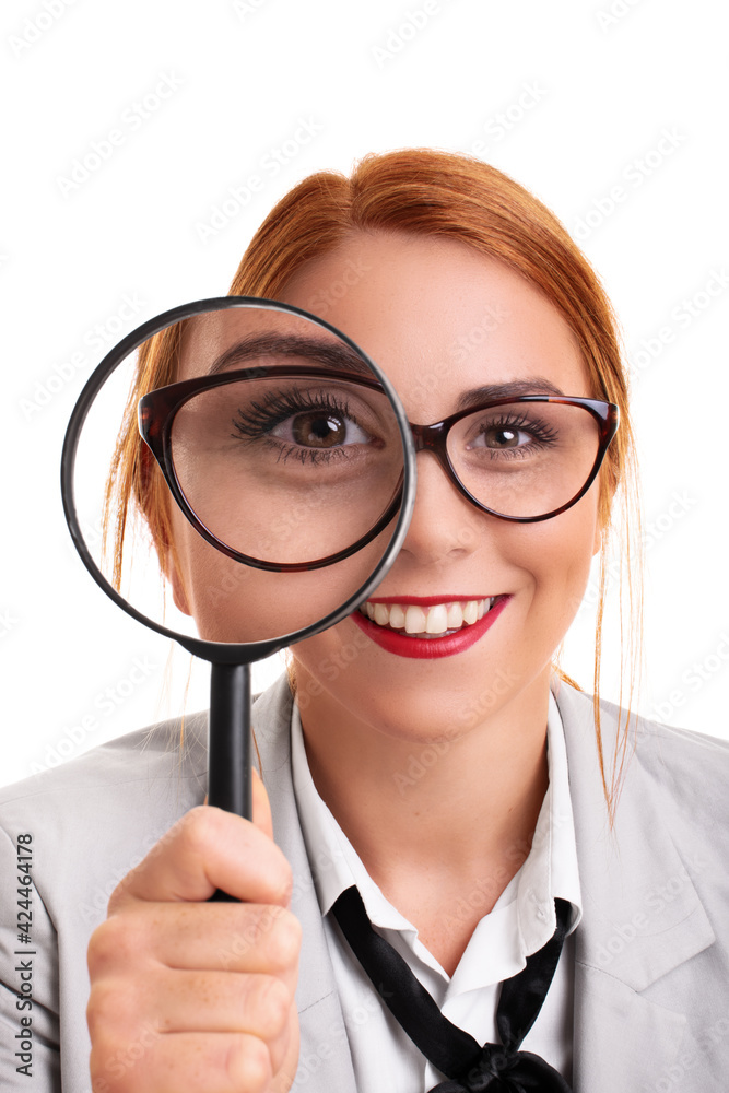 Young businesswoman smiling and looking through magnifying glass Young businesswoman smiling and looking through magnifying glass