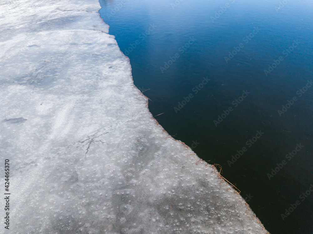 Melting ice edge on the river. Aerial drone view.