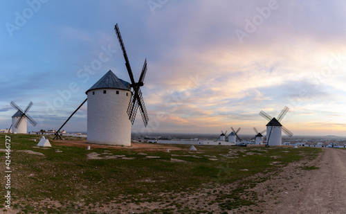 view of the historic white windmills of La Mancha above the town of Campo de Criptana at sunset