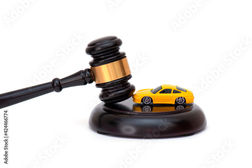 Foto Yellow car on wooden judge gavel isolated on white, concept picture about car credit debt or divorce