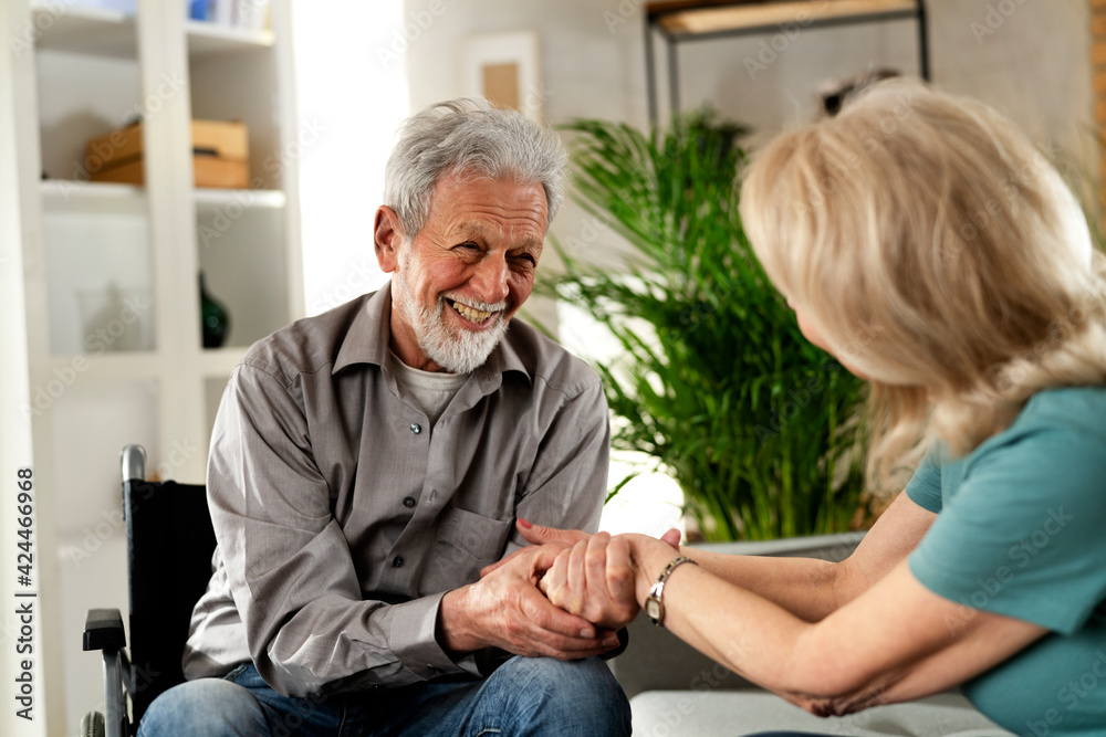 Elderly man in wheelchair. Happy husband and wife talking. Elderly man in wheelchair. Happy husband and wife talking.