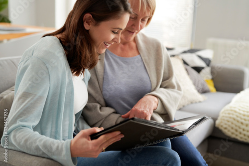 Mother and daughter looking at photo album