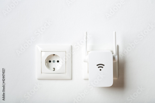 white wi-fi repeater indoors at home in outlet. wireless router photo