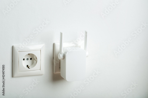 white wi-fi repeater indoors at home in outlet. wireless router photo