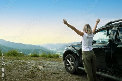 Happy tourist travelling by car in mountains. Freedom concept.