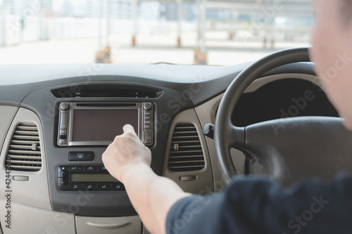 man using navigation system while driving a car. GPS navigation panel on dashboard inside a car. Finger pointing on destination point.
