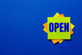 The word OPEN is written on bright stickers on a blue background
