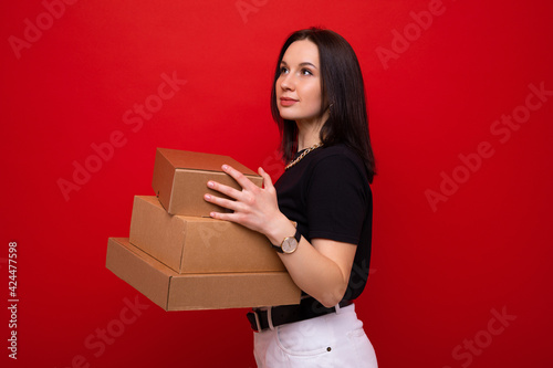 Young woman with paper boxes on red background © makedonski2015