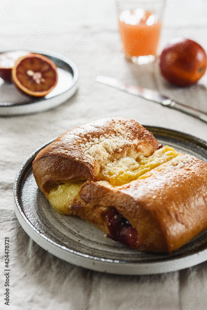 Breakfast with Twisted Bun with cheese and jam, juice and oranges. Red-Jam and Cheese Danish. Selective focus Breakfast with Twisted Bun with cheese and jam, juice and oranges. Red-Jam and Cheese Danish. Selective focus