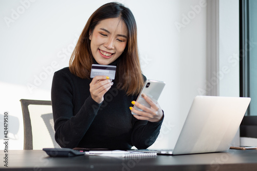 Portrait of Young woman using credit card and smartphone for buying online shopping at home ,payment,buying and online shopping concept.