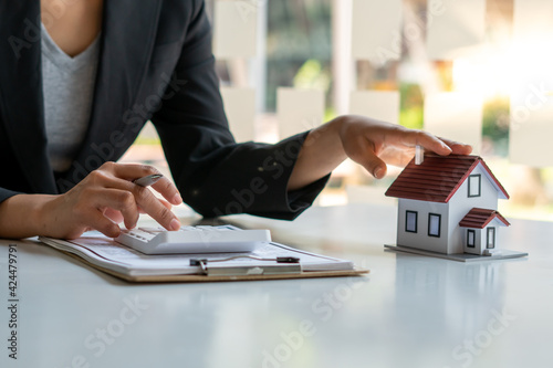 Fotografía A real estate broker or insurance agent works with home models and home real estate sales contracts within the office, Mortgage loan approval home loan and insurance concept
