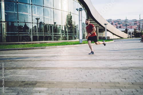 Sportsman running against modern glass building