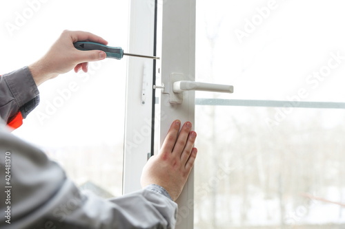 window repair service. adjustment of plastic window close-up 