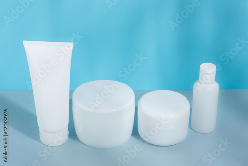 A set of cosmetic tubes for cream, different sizes, clean, white without inscriptions, on a gray-blue background, mockup, template © Ivan