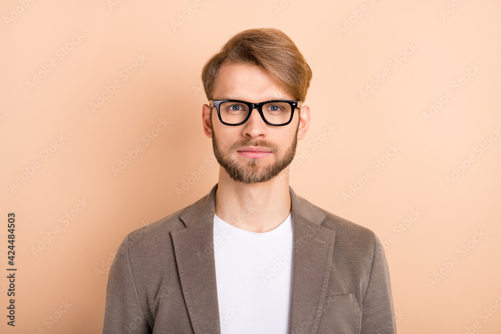 Photo of serious confident young guy wear jacket spectacles isolated beige color background Photo of serious confident young guy wear jacket spectacles isolated beige color background