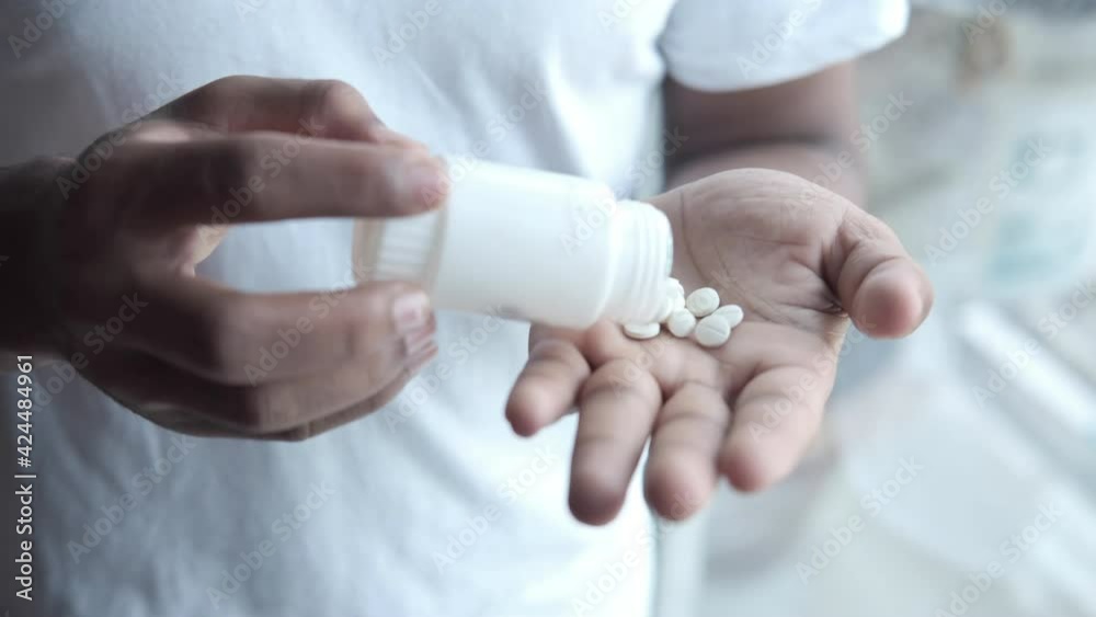 man's hand with medicine spilled out of the pill container man's hand with medicine spilled out of the pill container