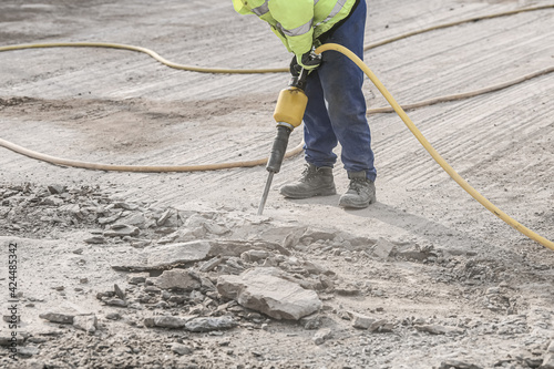 Demolition hammer. Male working in construction industry. Repairing and building a new road.