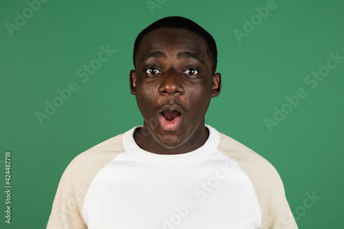 African man's portrait isolated on green studio background with copyspace