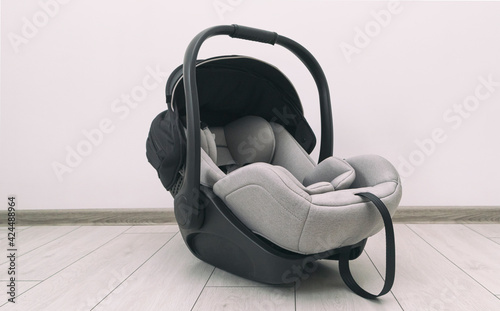 Empty baby car seat on the floor in the house photo