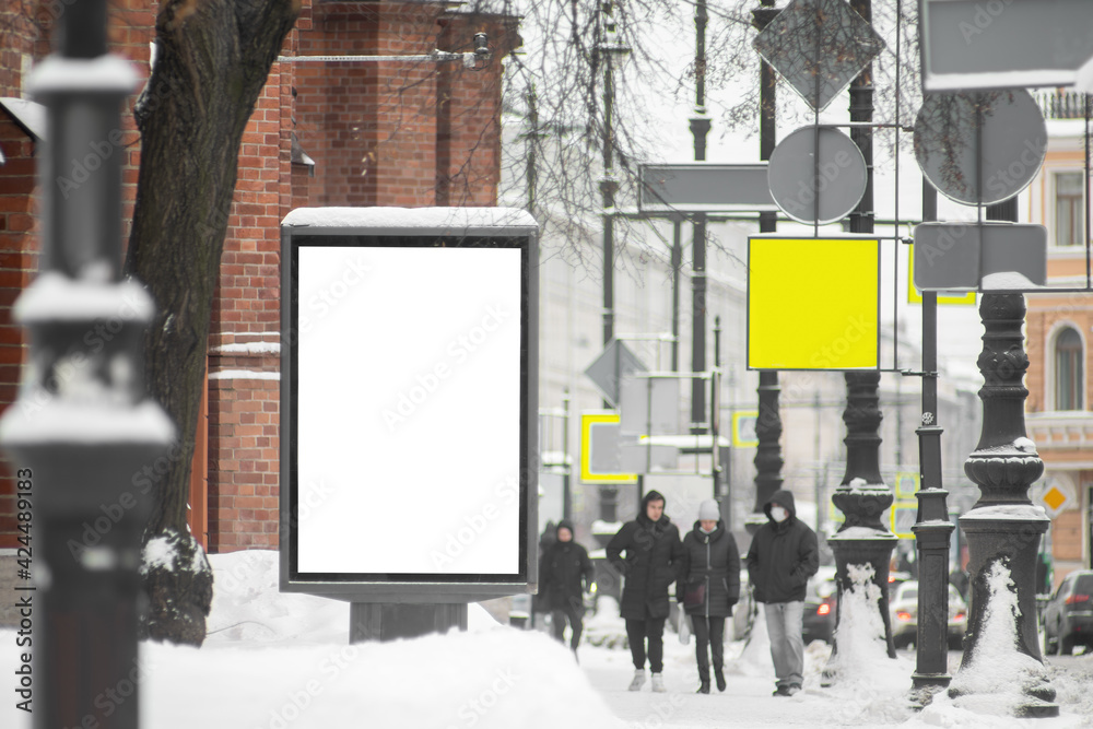 Billboard vertical in the city. With snow in winter.