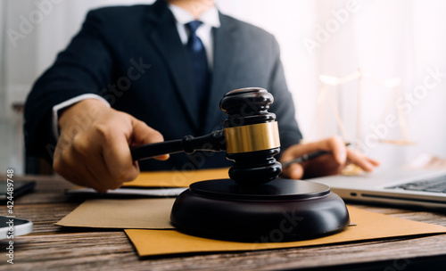 Business and lawyers discussing contract papers with brass scale on desk in office. Law, legal services, advice, justice and law concept picture with film grain effect