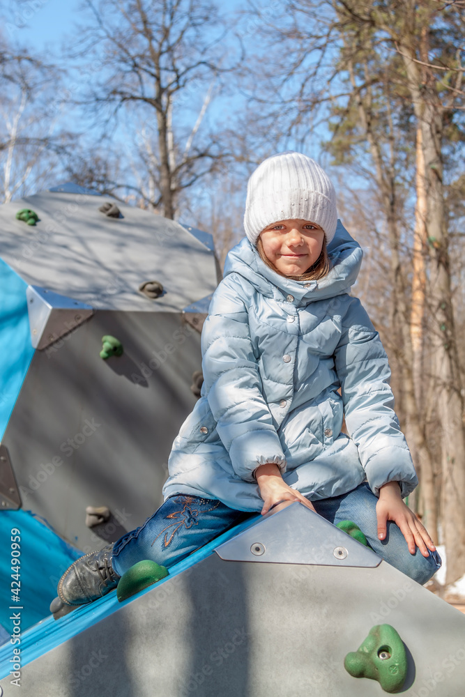 little girl on sunny spring day Smiling and having good time on kids climbing equipment on playground. Portrait of adorable child outdoors on spring day. little girl on sunny spring day Smiling and having good time on kids climbing equipment on playground. Portrait of adorable child outdoors on spring day.