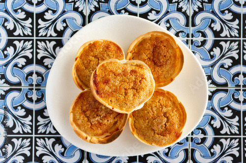 Traditional Portuguese pastry called Queijada de Sintra on portuguese tiles background photo