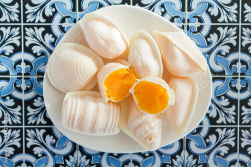 Top view of traditional portuguese egg yolk sweets called Ovos Moles de Aveiro on portuguese tiles background photo