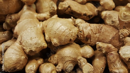 Ginger roots (Zingiber officinale) in a traditional vegetable market scattered loosely with selective focus, full frame close up.