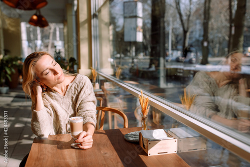 Beautiful woman in a cafe enjoying the sun