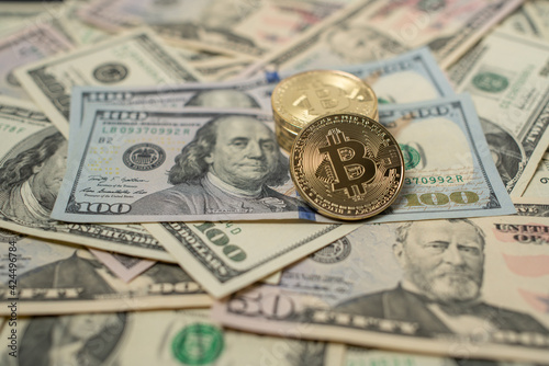 Bitcoin Crypto currency with US Dollar banknotes. Crypto Coins and 100 Dollar Bills. Digital currency on top of fiat money